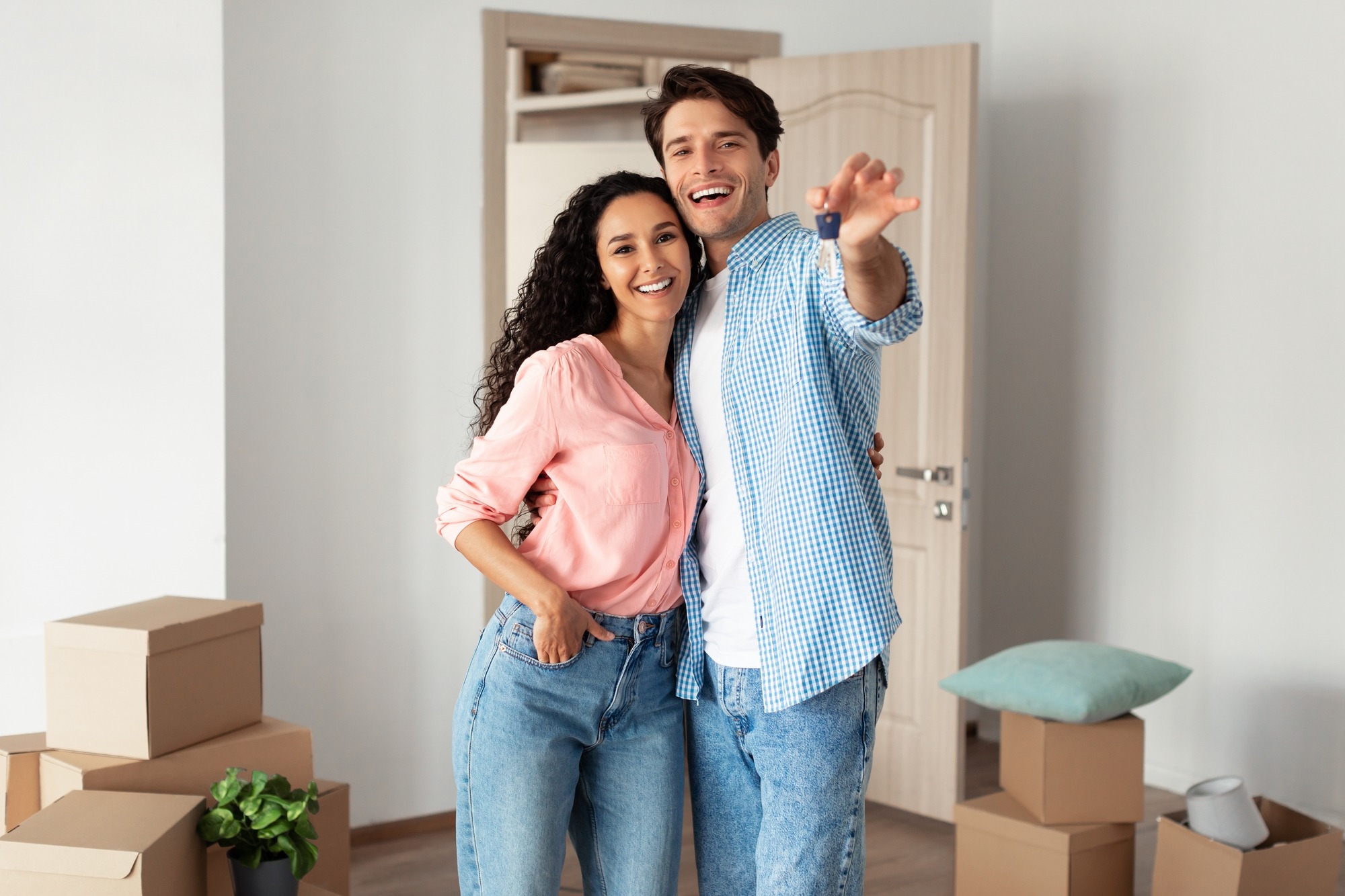 House Ownership. Portrait Of Happy Young Couple Holding Showing Key Standing In New Flat